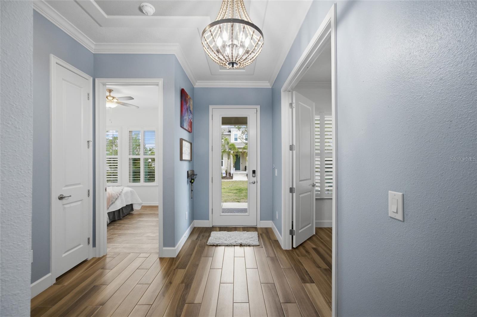 High ceilings, crown molding, ceramic tile wood look flooring and custom light fixture welcome you in.