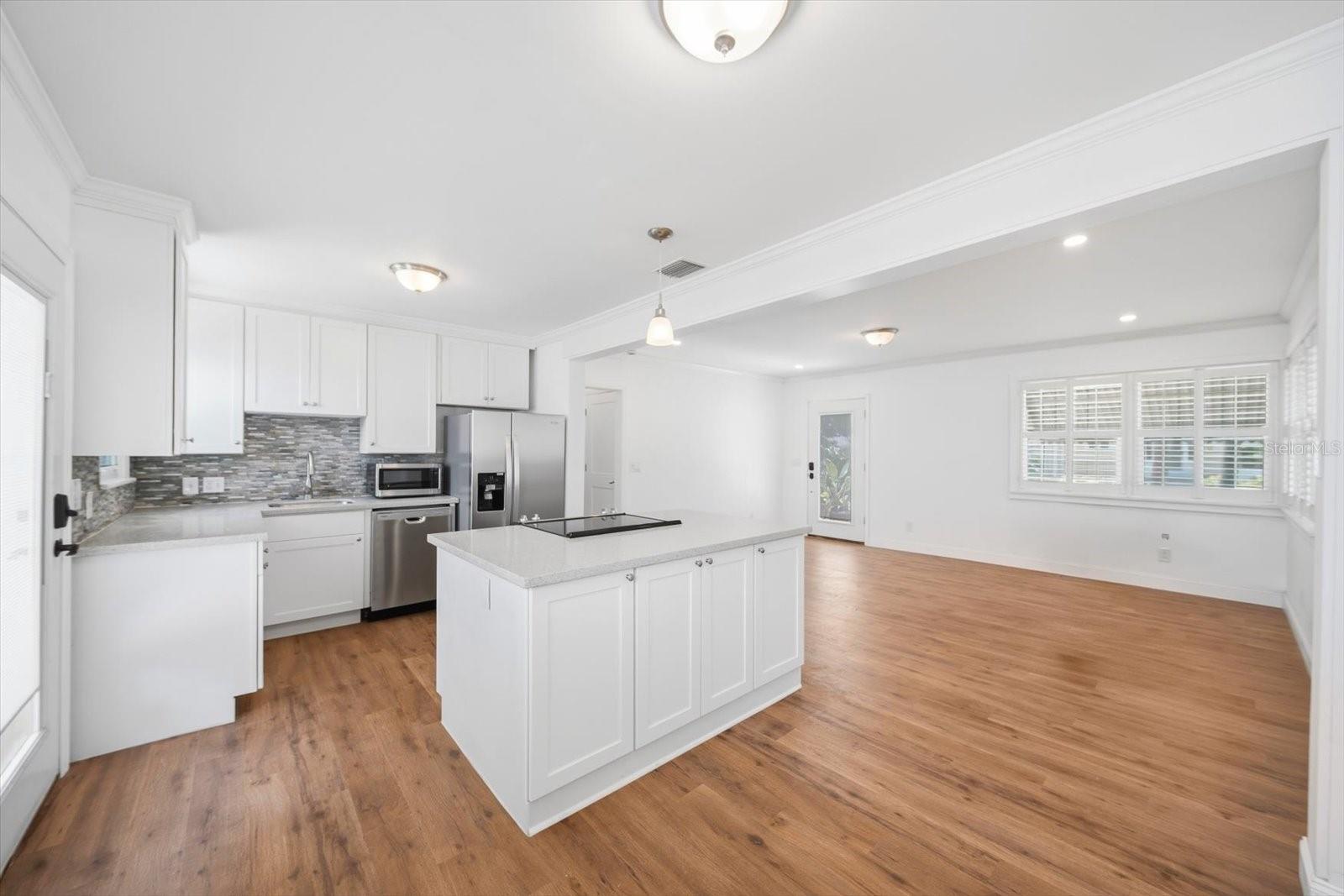 Facing the living room showcasing the updated kitchen and cooking island with storage