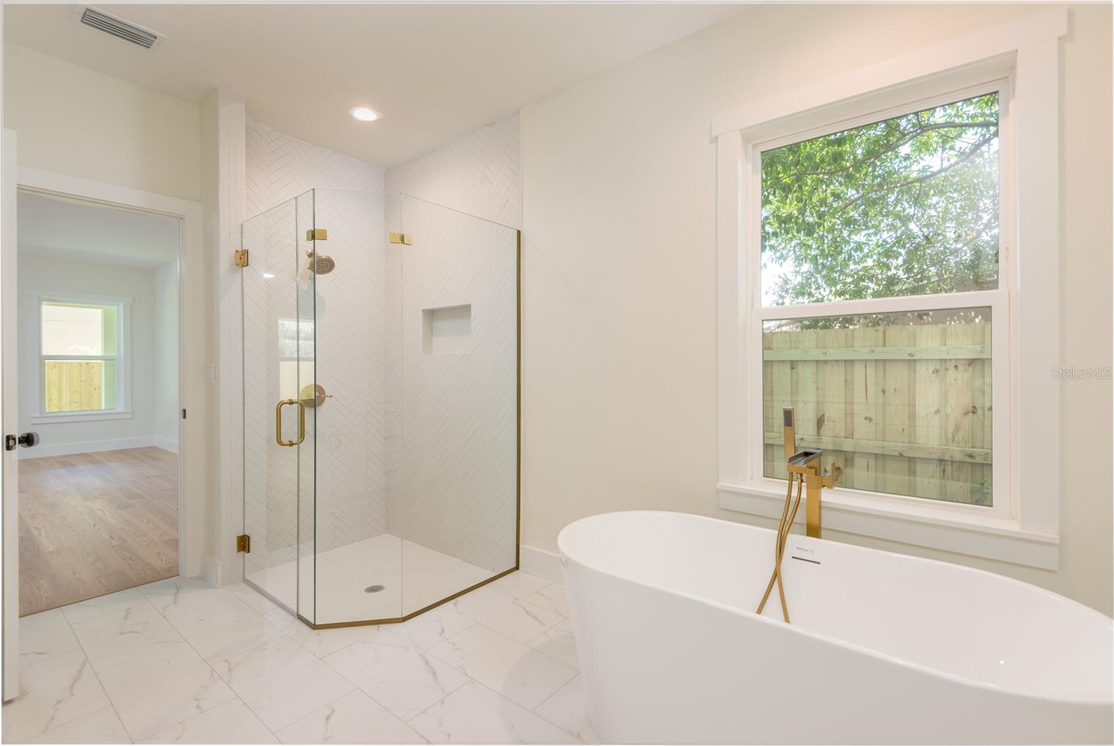 Primary bathroom with walk-in shower, free standing tub, toilet closet, linen closet and double vanity.