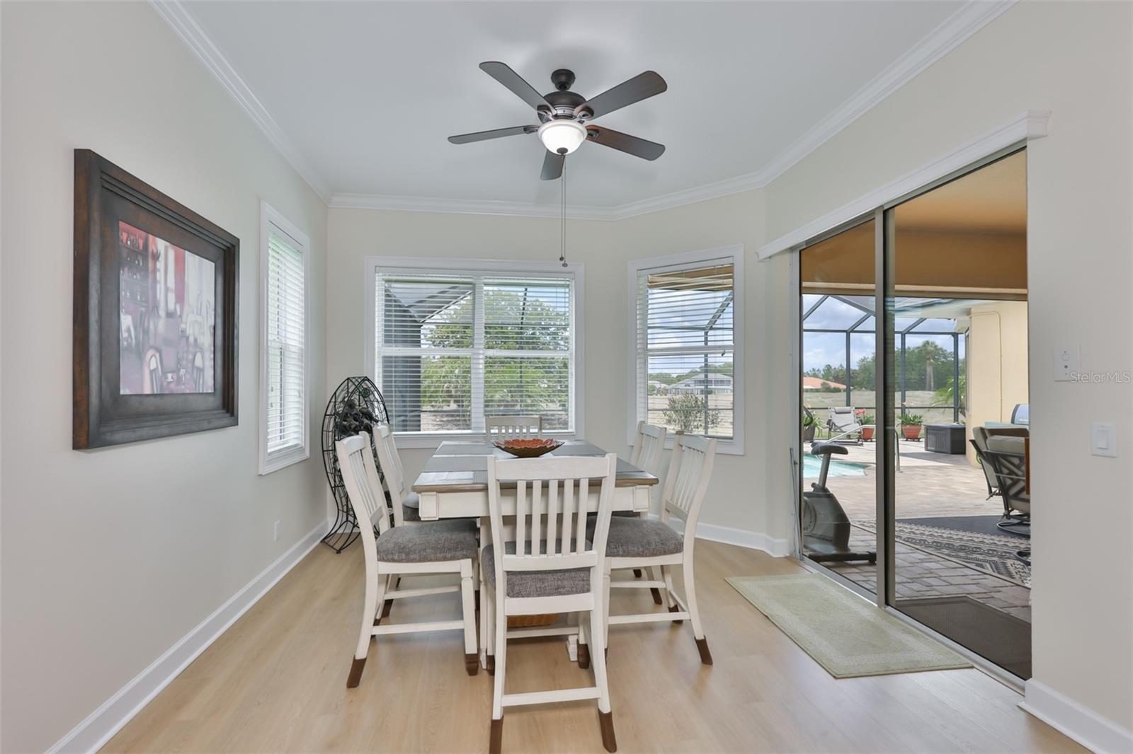 The dining room is bright and open and looks right onto the covered lanai and pool.