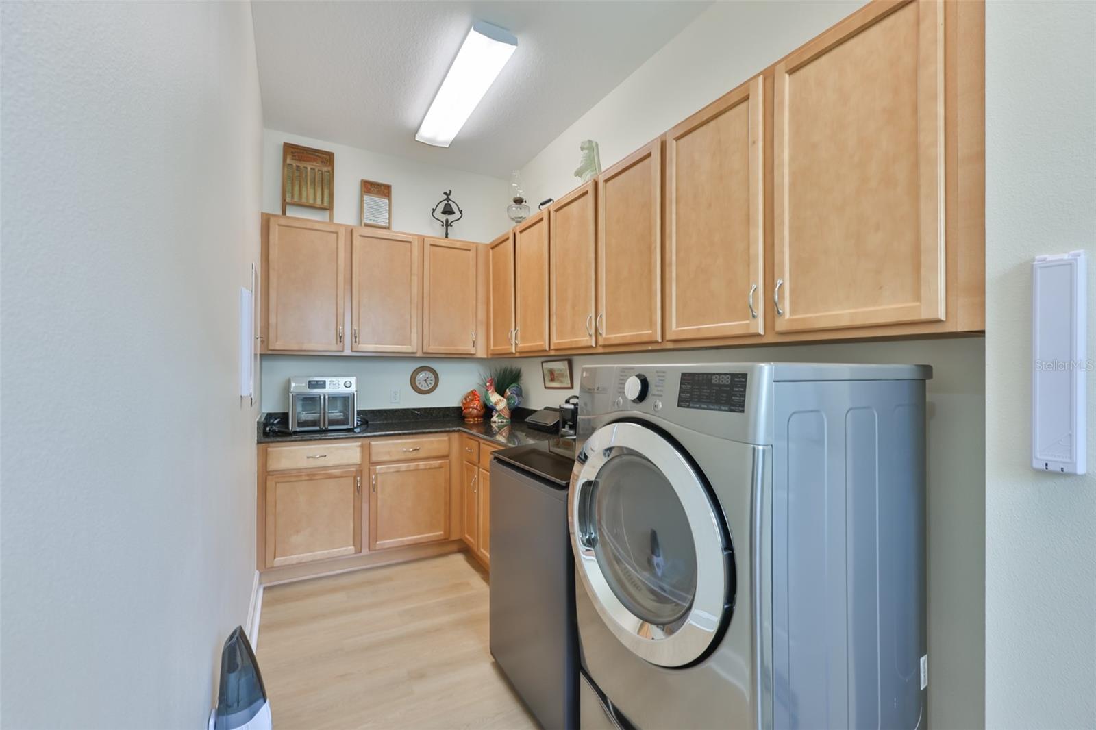 Laundry room is incredible with lots of granite counter tops and all wood cabinets.