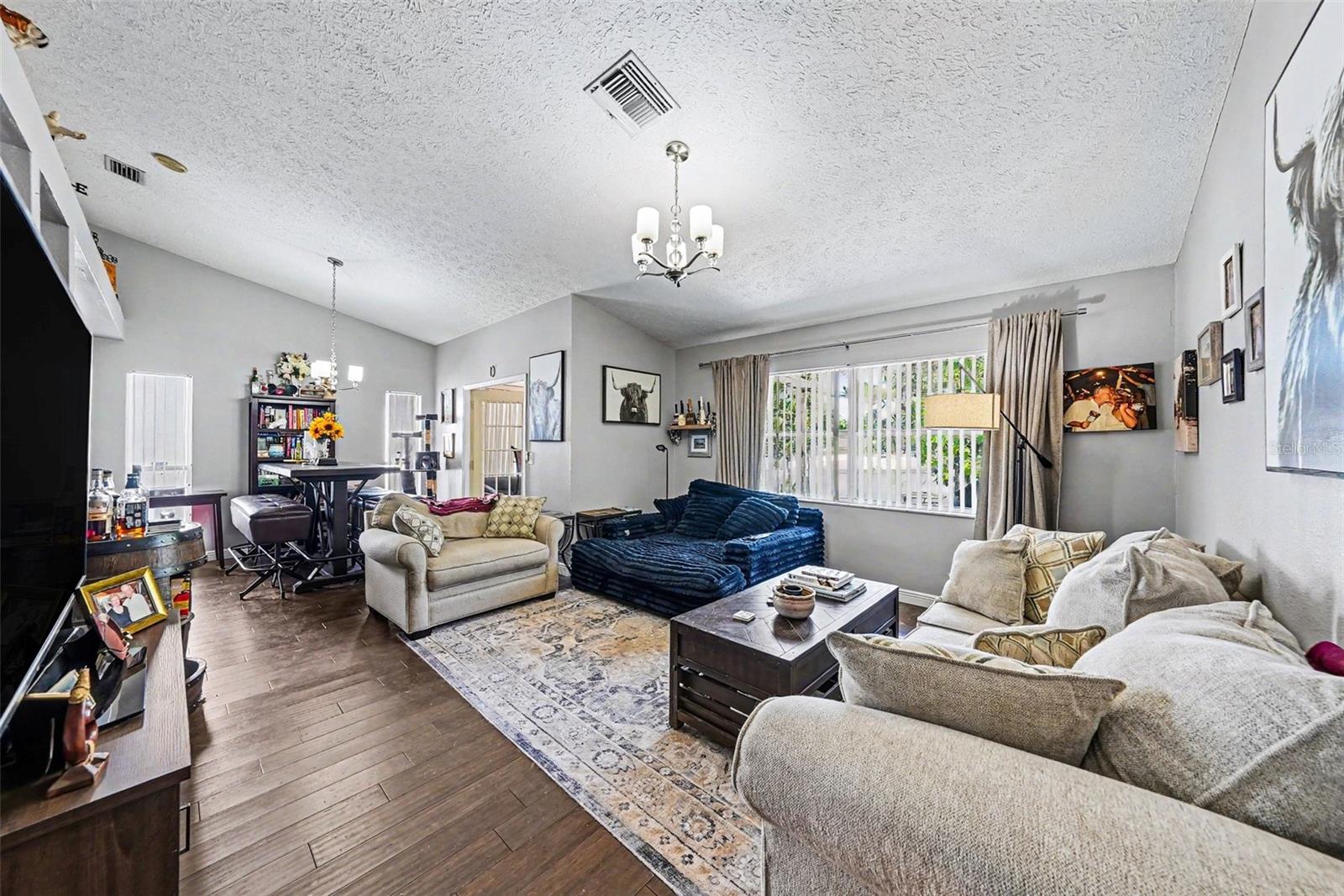 Living room with dining room space, bar to the kitchen, and sunroom