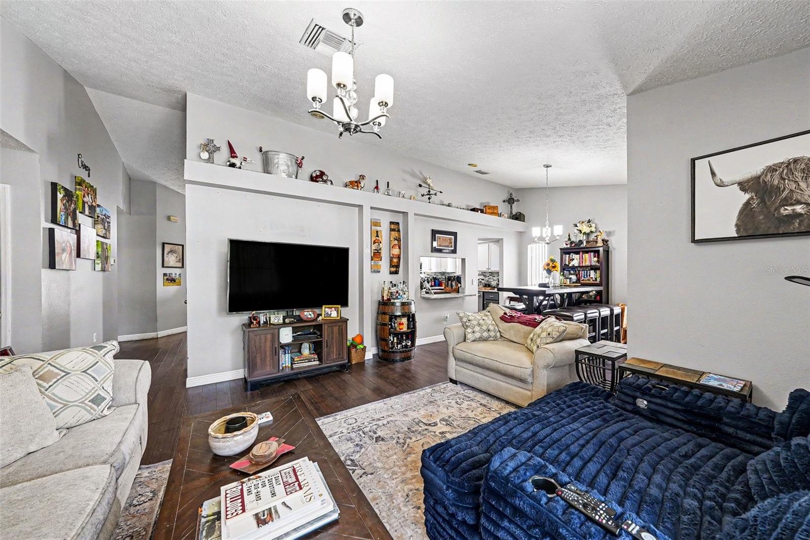 Living room with dining room space, bar to the kitchen, and sunroom