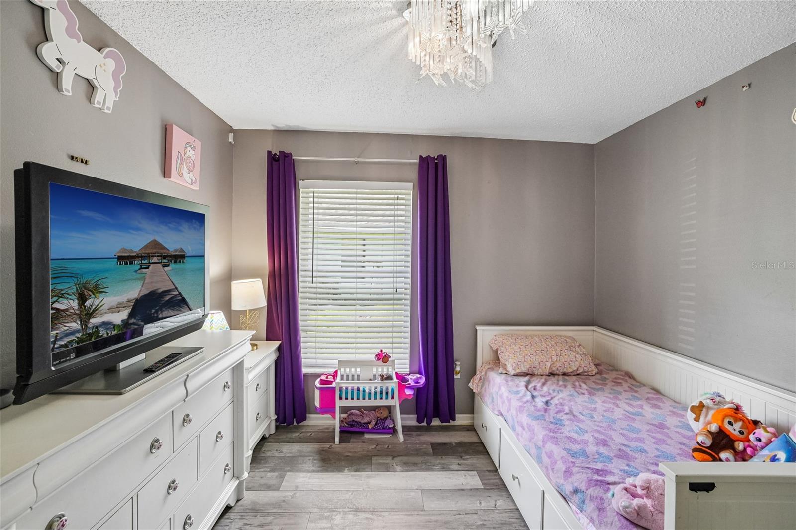 Secondary bedroom with luxury vinyl plank flooring, a crystal flush-mount light fixture