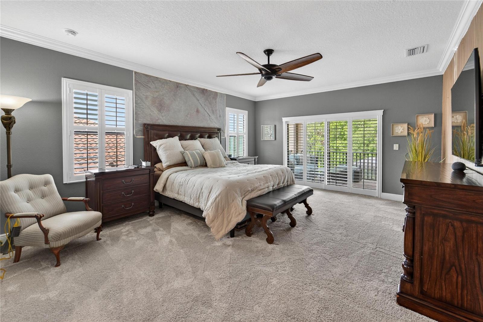 Owner suite with access to upstairs rear balcony along with accent wall. You will enjoy the plantation shutters throughout the home.