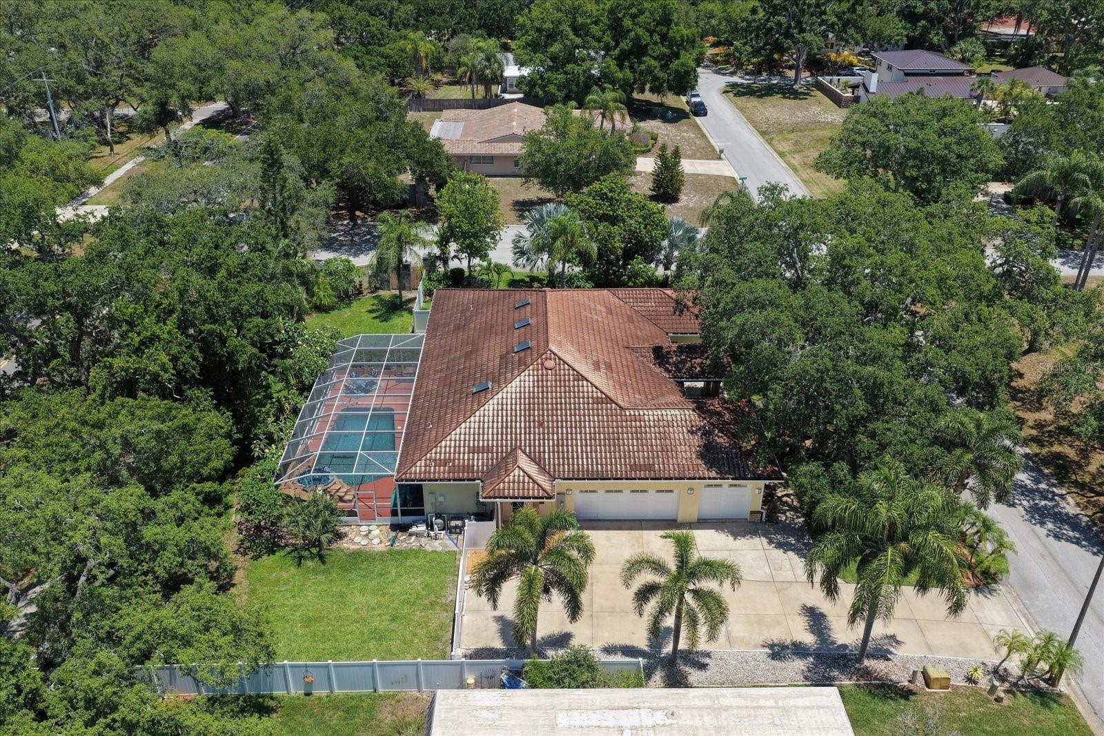 Closer Ariel View of 3 Car Garage, enclosed Pool, and side yard