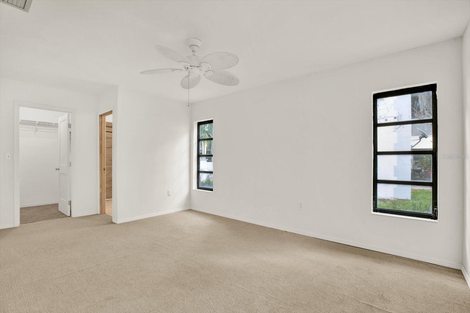 Spacious primary suite featuring bright natural light, a private bathroom and a large walk in closet.