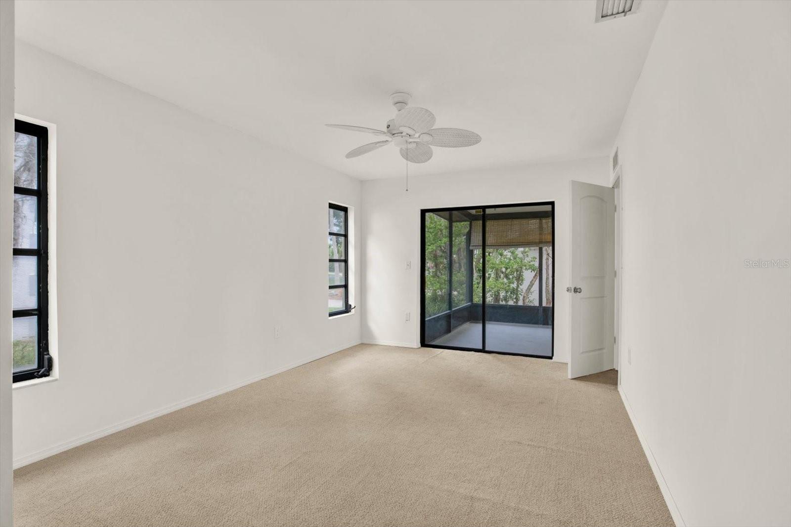 Primary bedroom offering  direct access to the private, screened in lanai through sliding glass doors.