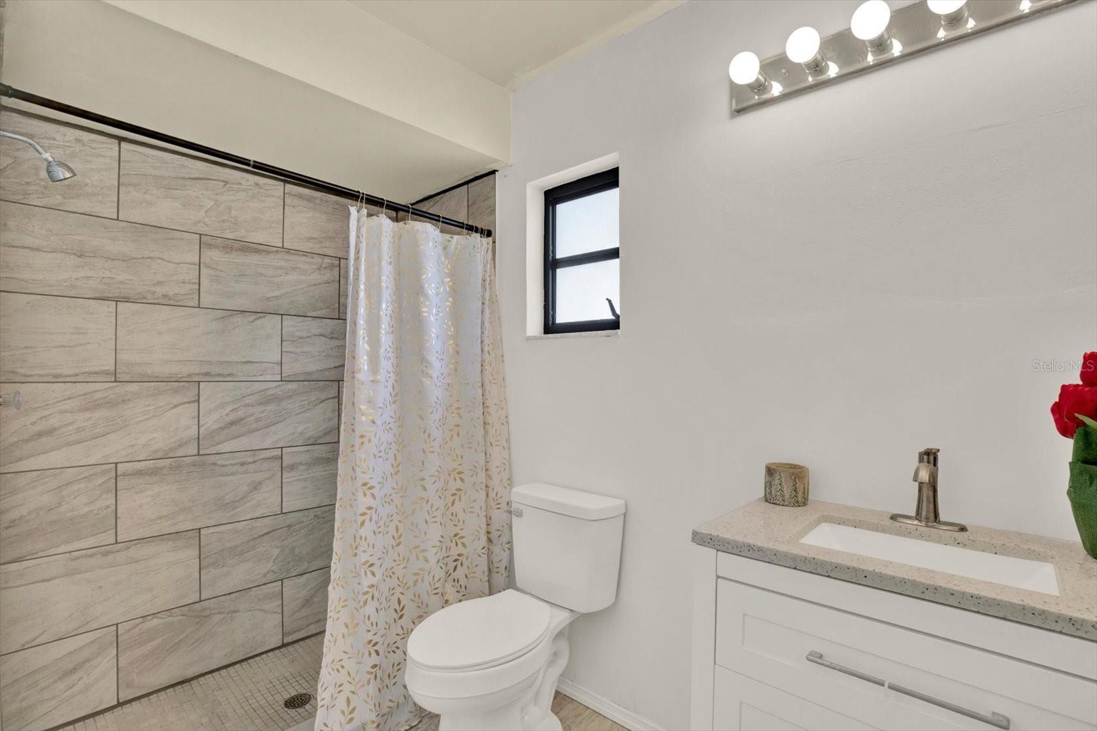Modern primary en-suite bathroom featuring a stylish single vanity and a beautifully tiled walk in shower.