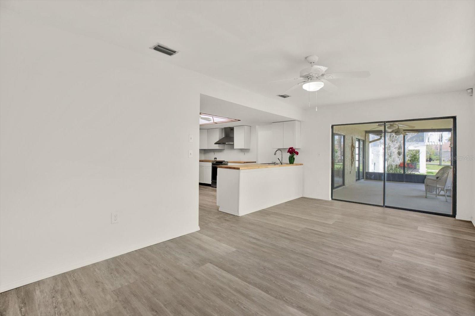 Bright open concept living area with seamless flow to the kitchen and screened lanai.