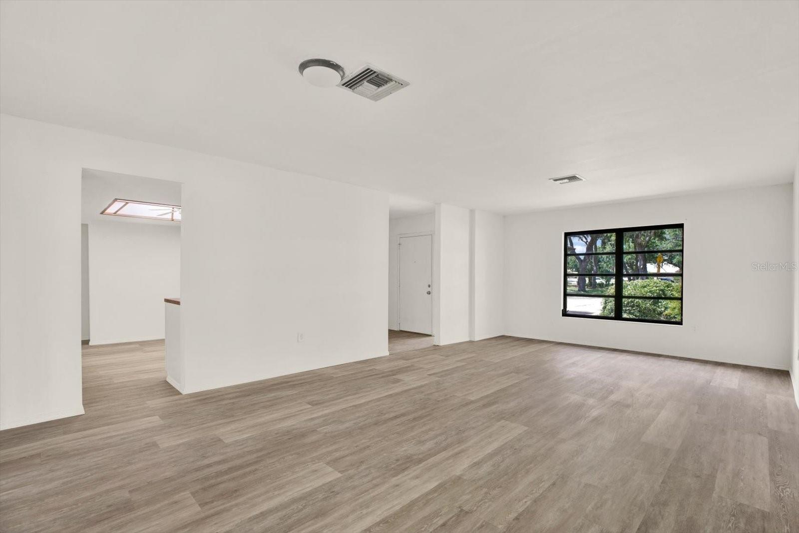 Spacious main living area featuring great natural light and modern luxury vinyl flooring.