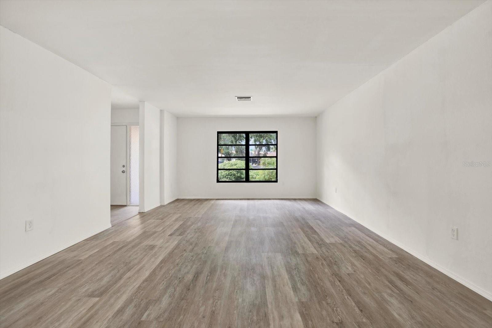 Alternative view of the massive living area highlighting the seamless flooring and flexible layout.