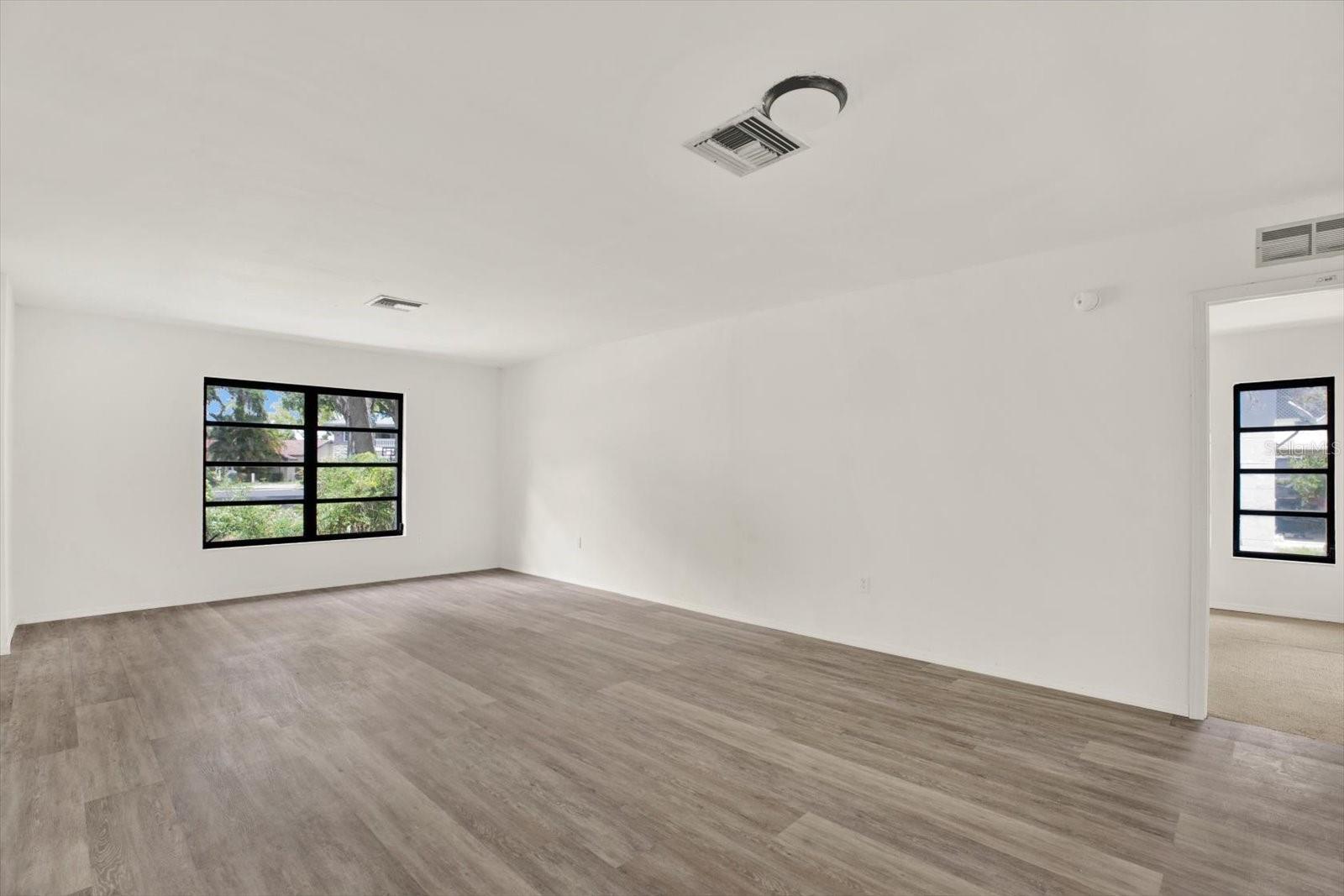 Living room view highlighting the easy transition into the private primary bedroom suite.