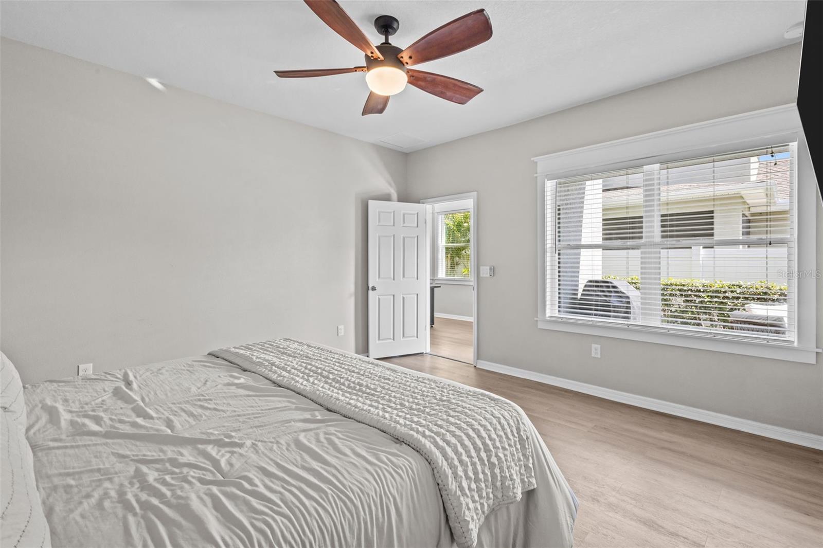 First-floor primary suite features upgraded flooring and custom wood window trim