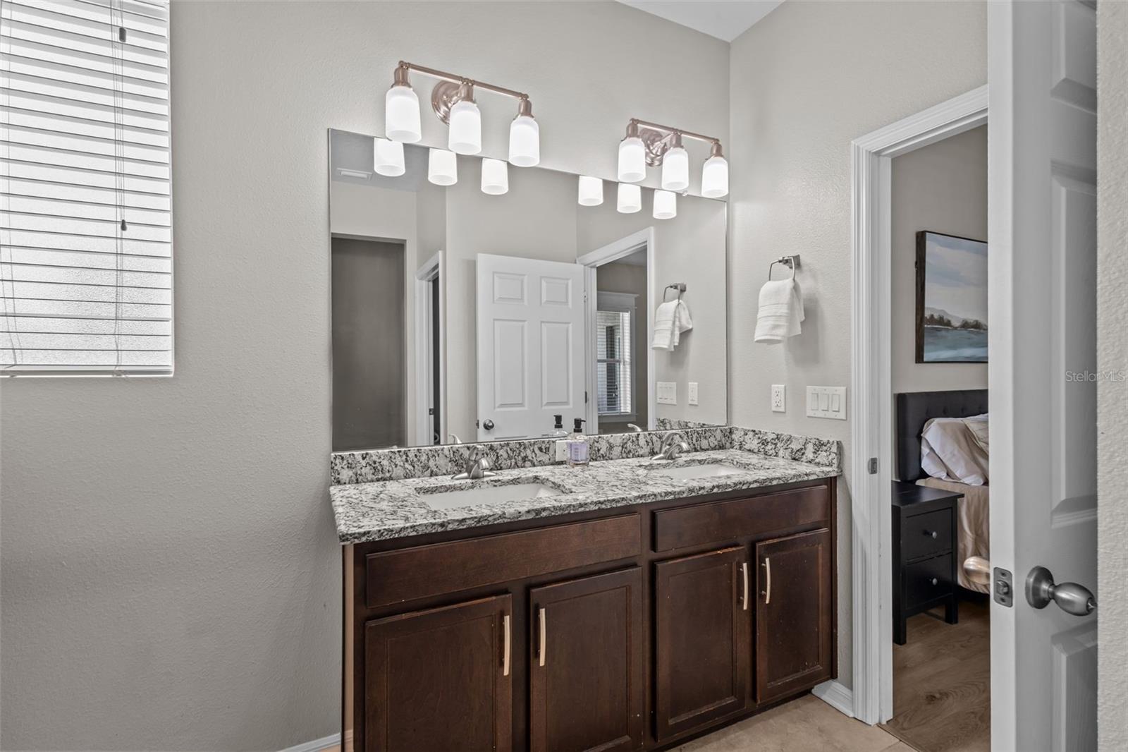 Primary bathroom features dual sinks, granite countertops, and a walk-in shower.