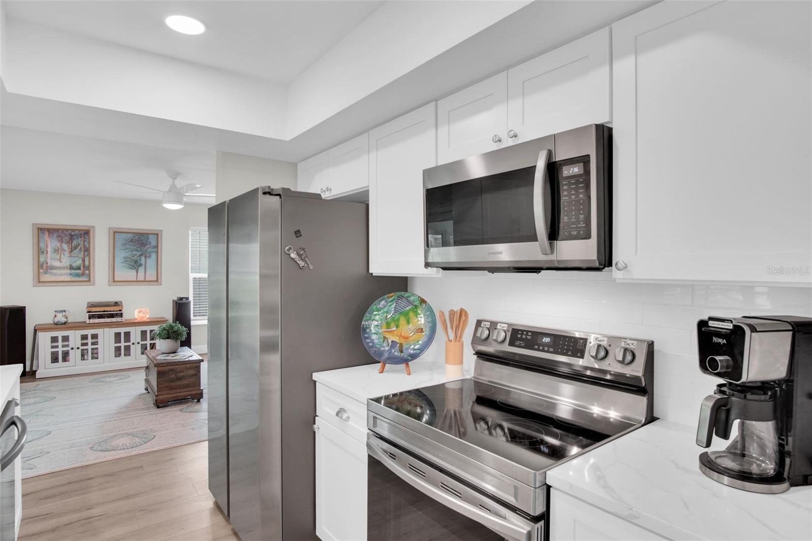Tray ceiling, recessed lighting, and sleek stainless appliances~