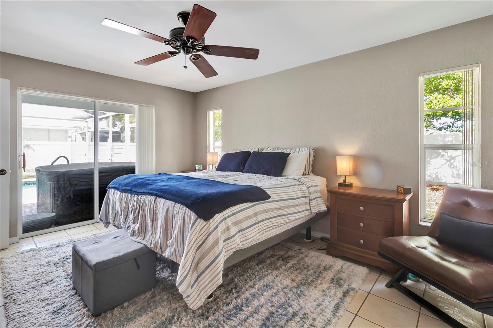 Primary Bedroom with Sliding Glass Doors to Lanai, Pool and Hot Tub