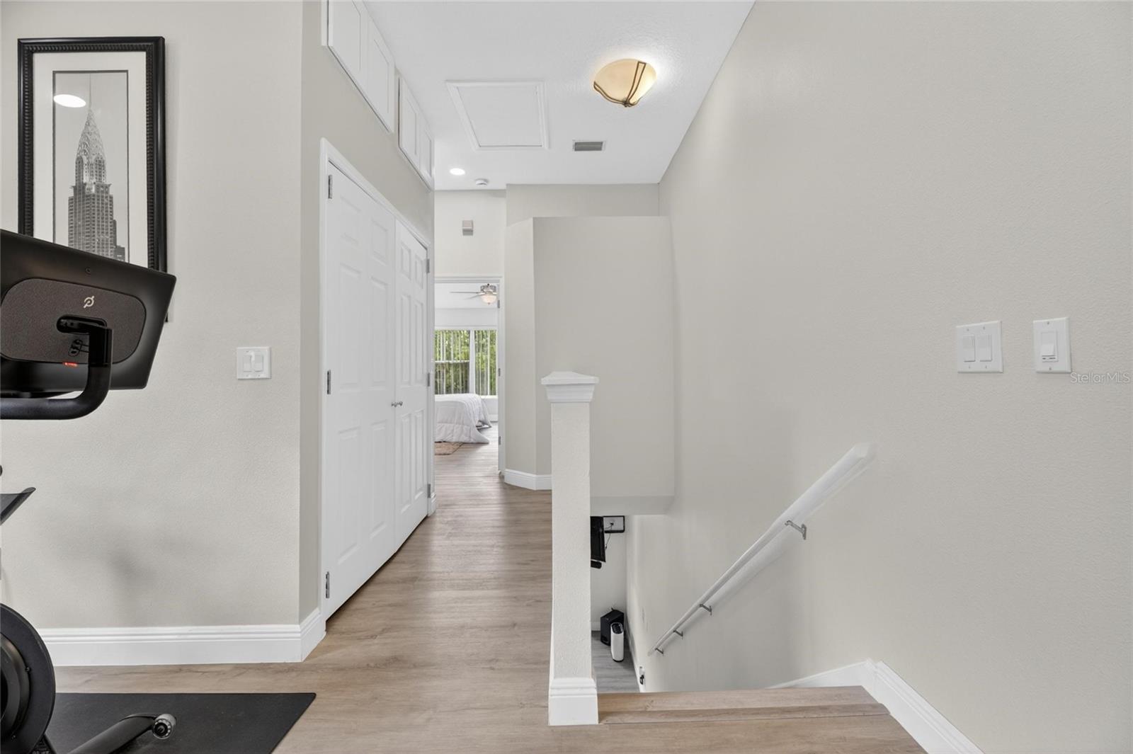 Hallway to Primary and Laundry closet with storage above
