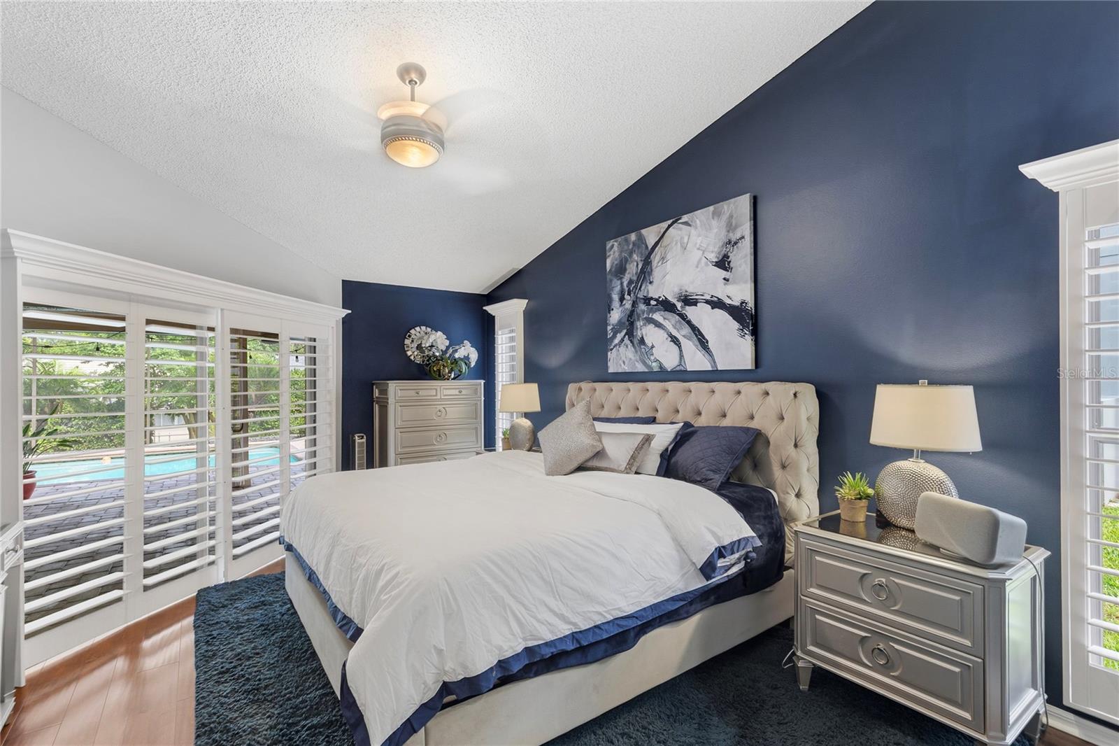 Master bedroom with plantation shutters and private sliding glass door entrance onto the lanai and pool