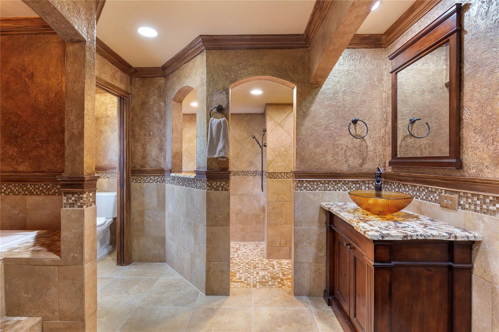 Large master bathroom with soaking tub, his and her sink cabinets, spacious walk-in shower and private toilet closet.