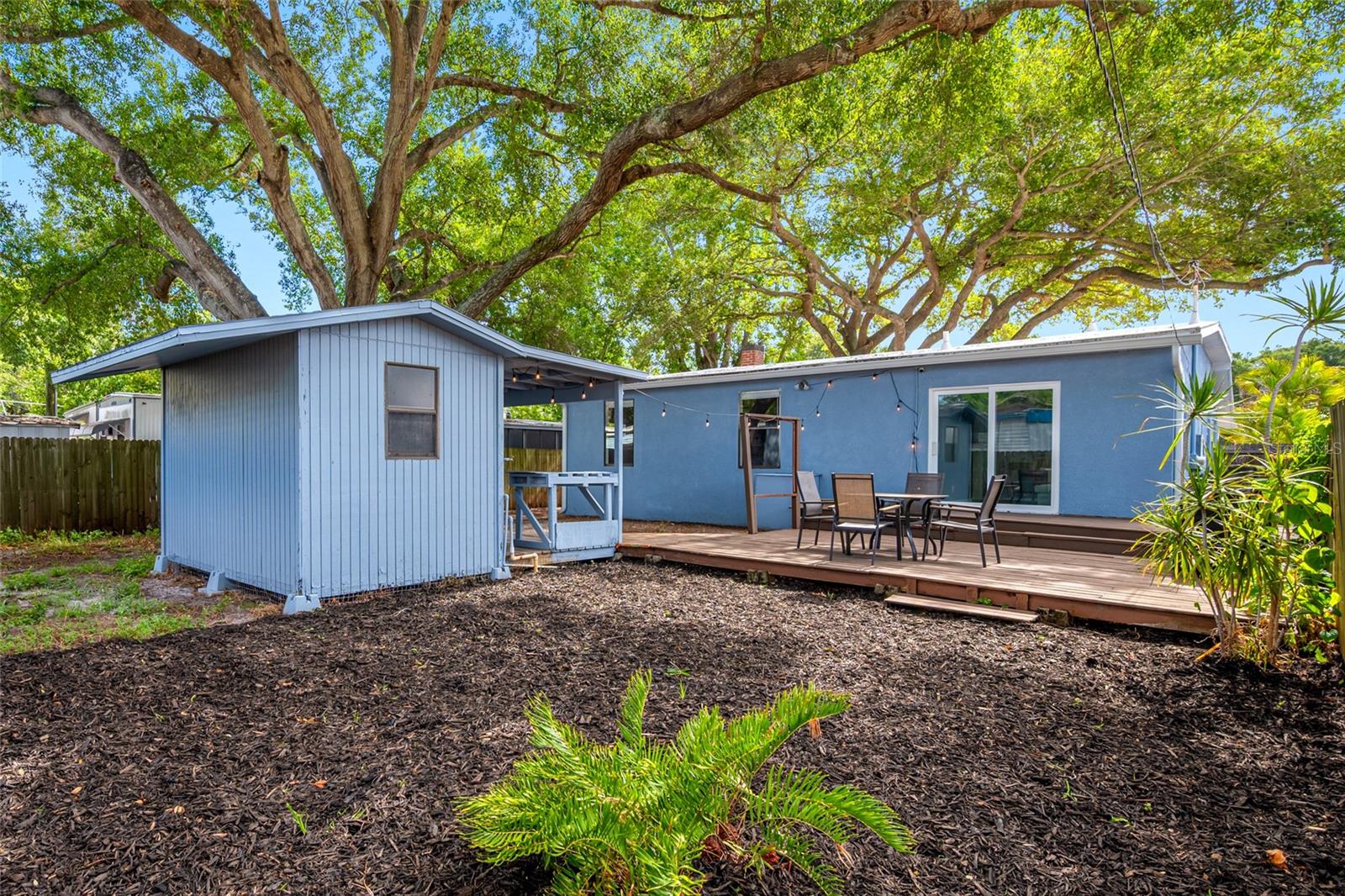 Fenced in back yard with 20ft wide deck that leads to detached workshop and shed.