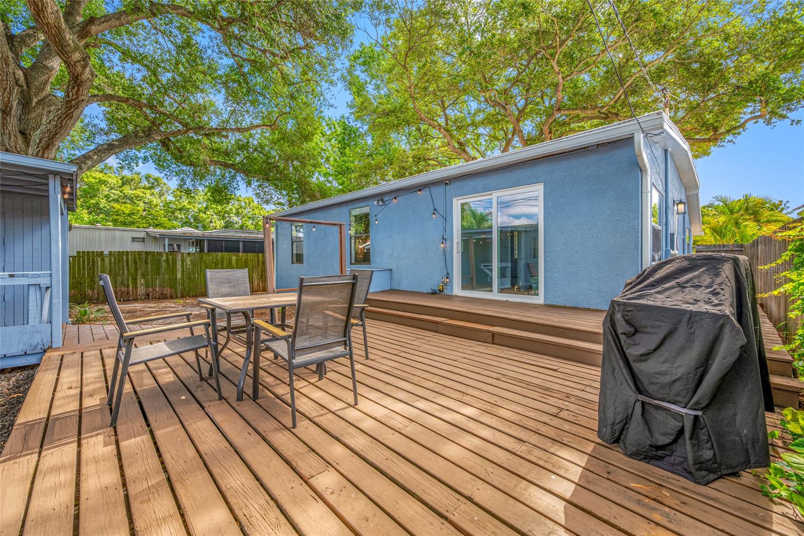 Fenced in back yard with 20ft wide deck that leads to detached workshop and shed.