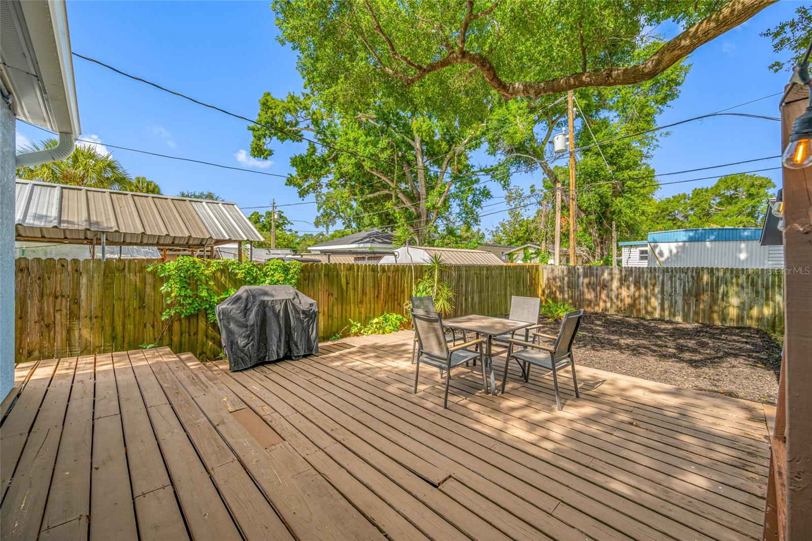 Fenced in back yard with 20ft wide deck that leads to detached workshop and shed.