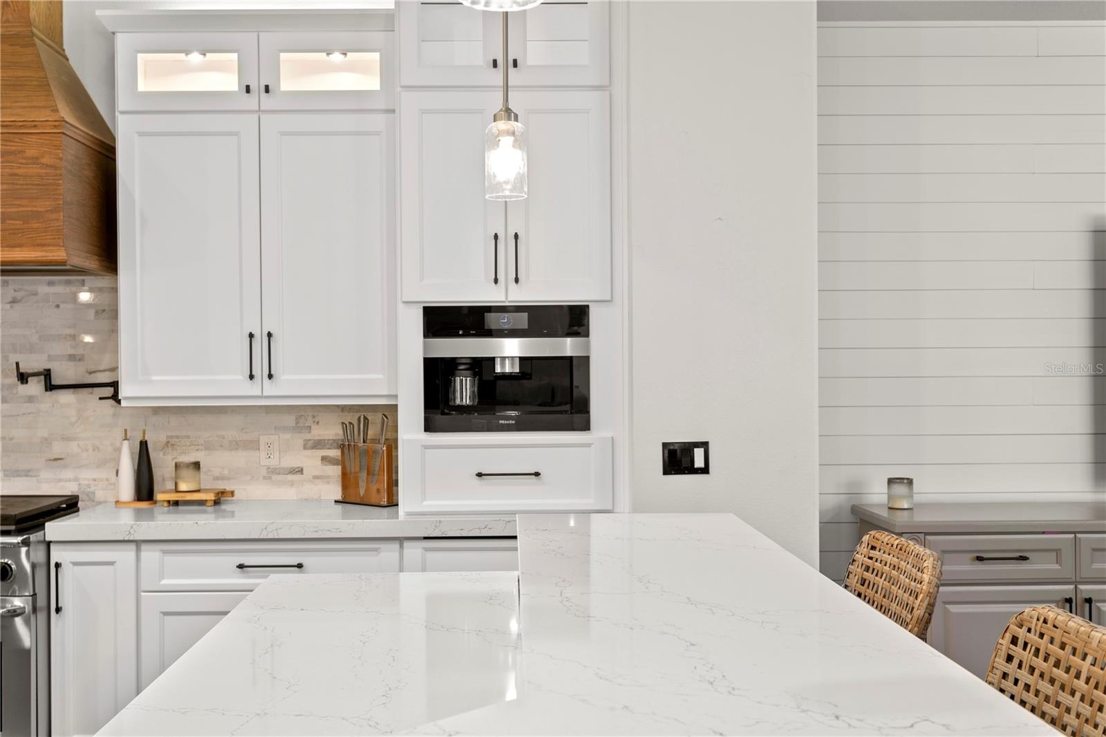 Premium Miele appliances including built-in coffee maker.