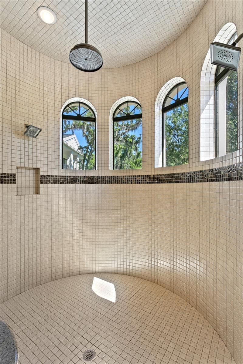 Oversized shower with triple shower heads.