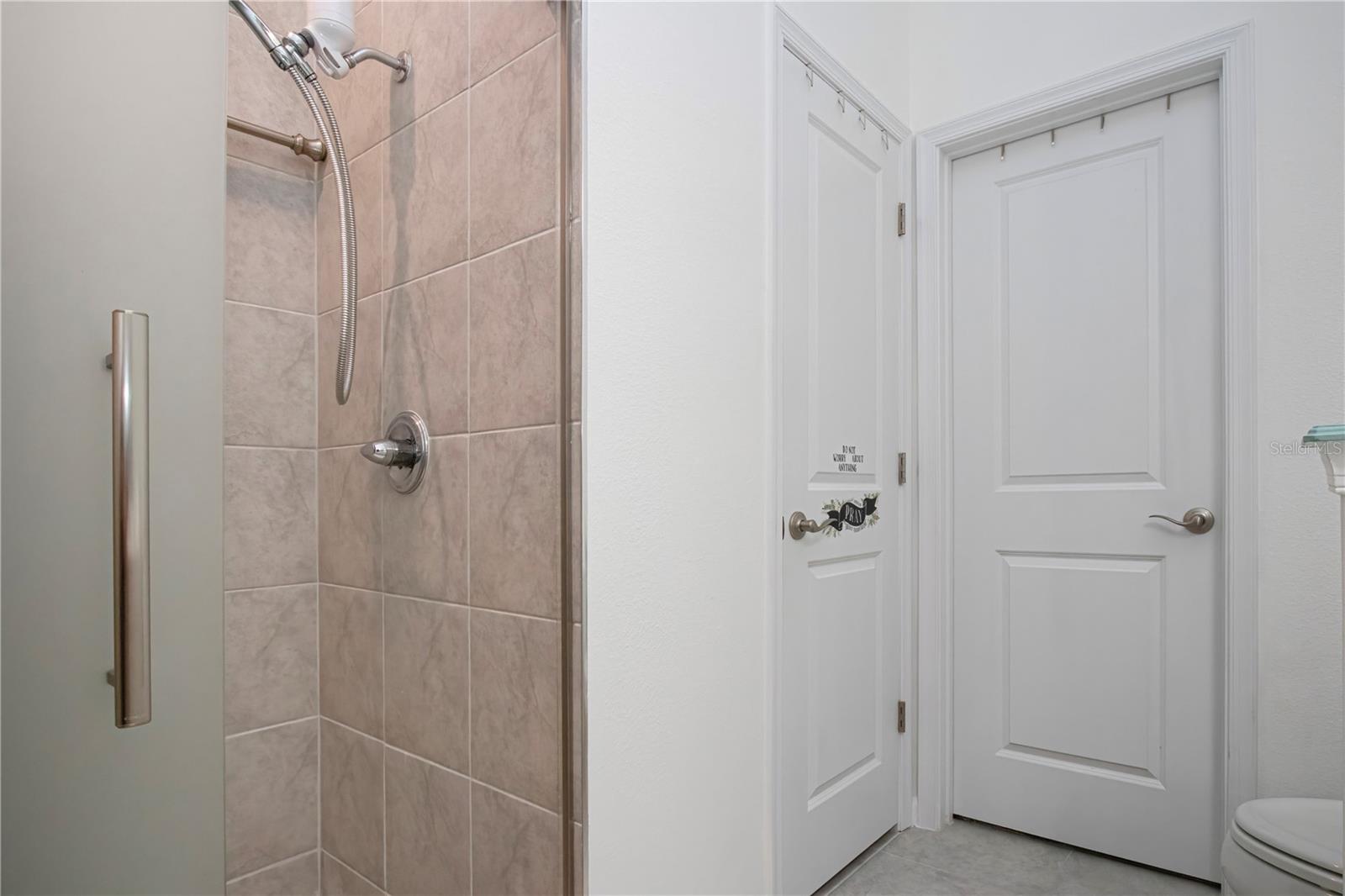 Primary Bathroom on first floor with walk-in shower and walk-in closet and linen storage