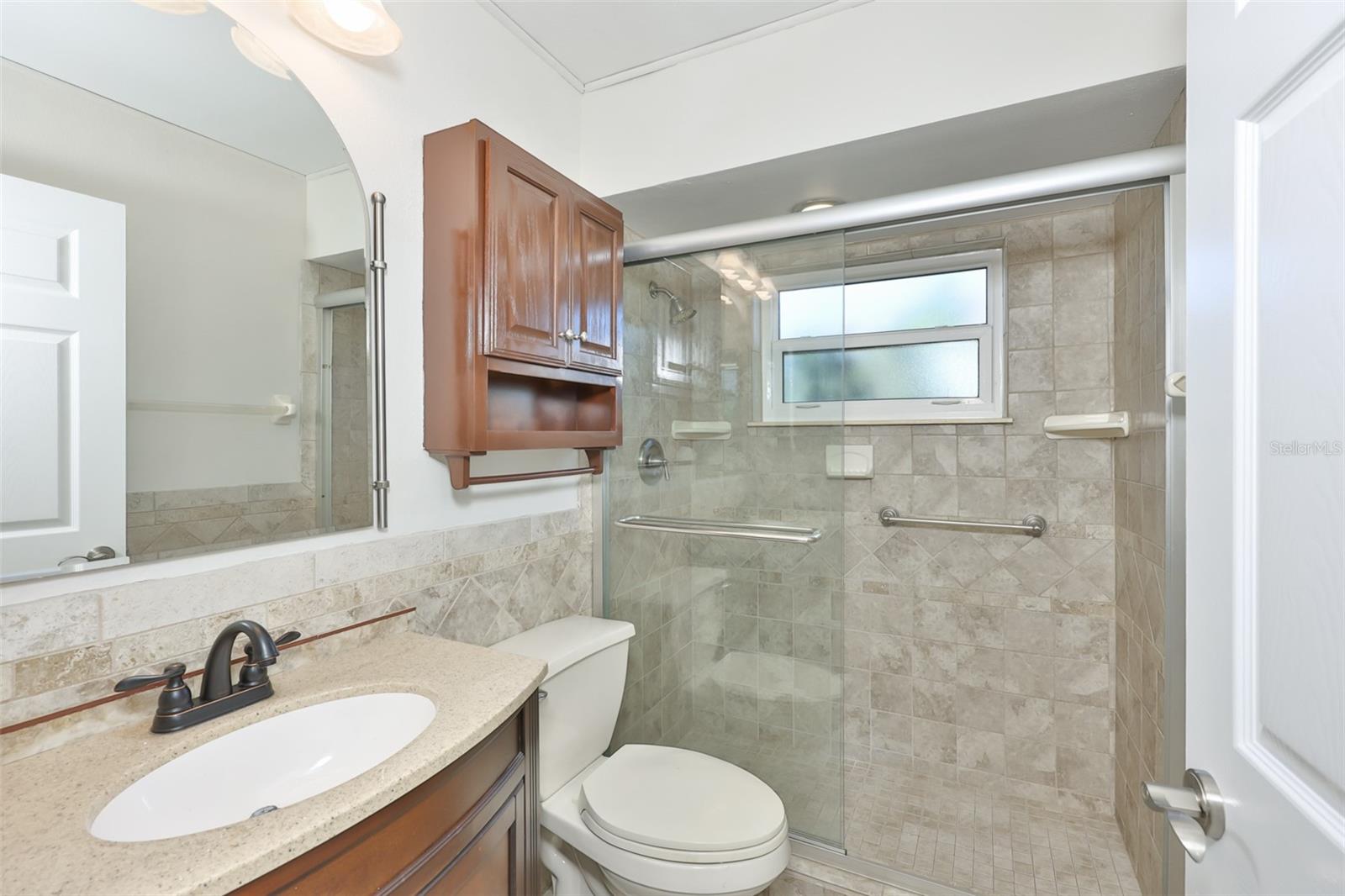 Bath 2, tiled shower with glass enclosure, vanity and granite counter.