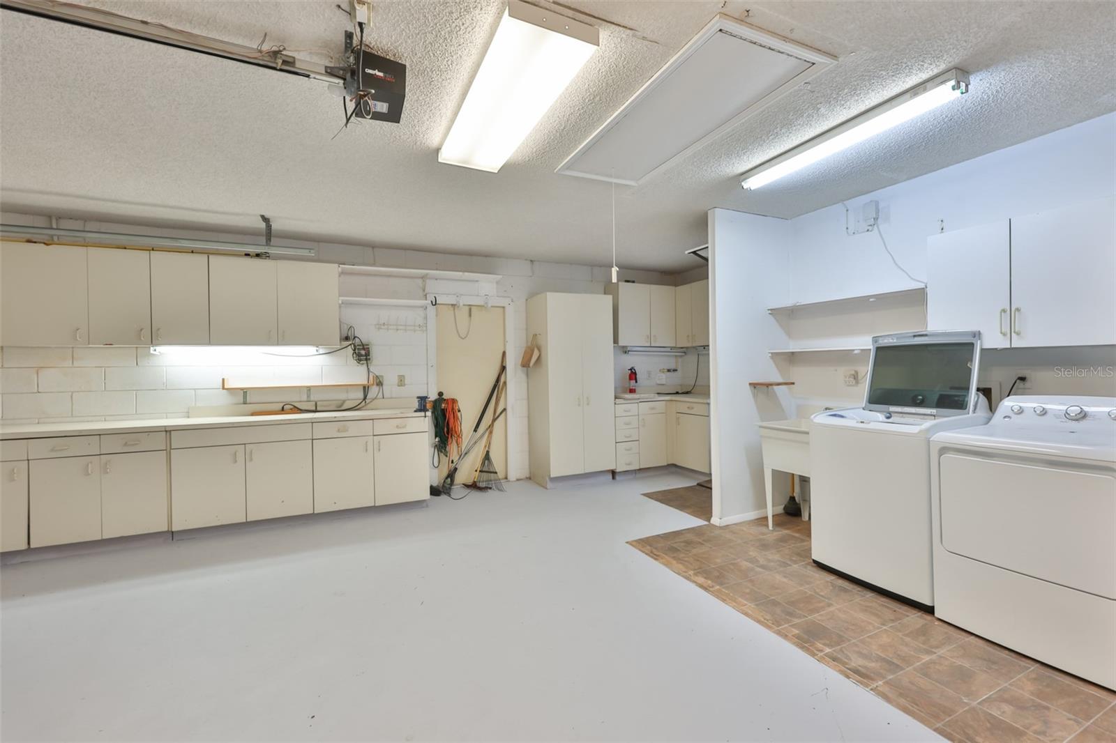 Built-in garage workshop and laundry. Plenty of cabinets for storage and a utility sink too.