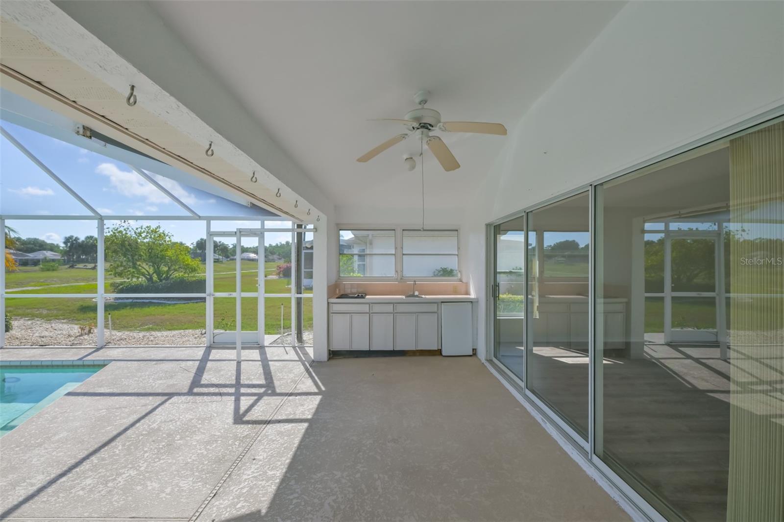 Outdoor kitchen; refrigerator, sink, grill! Ceiling fan to keep you cool in the shade.