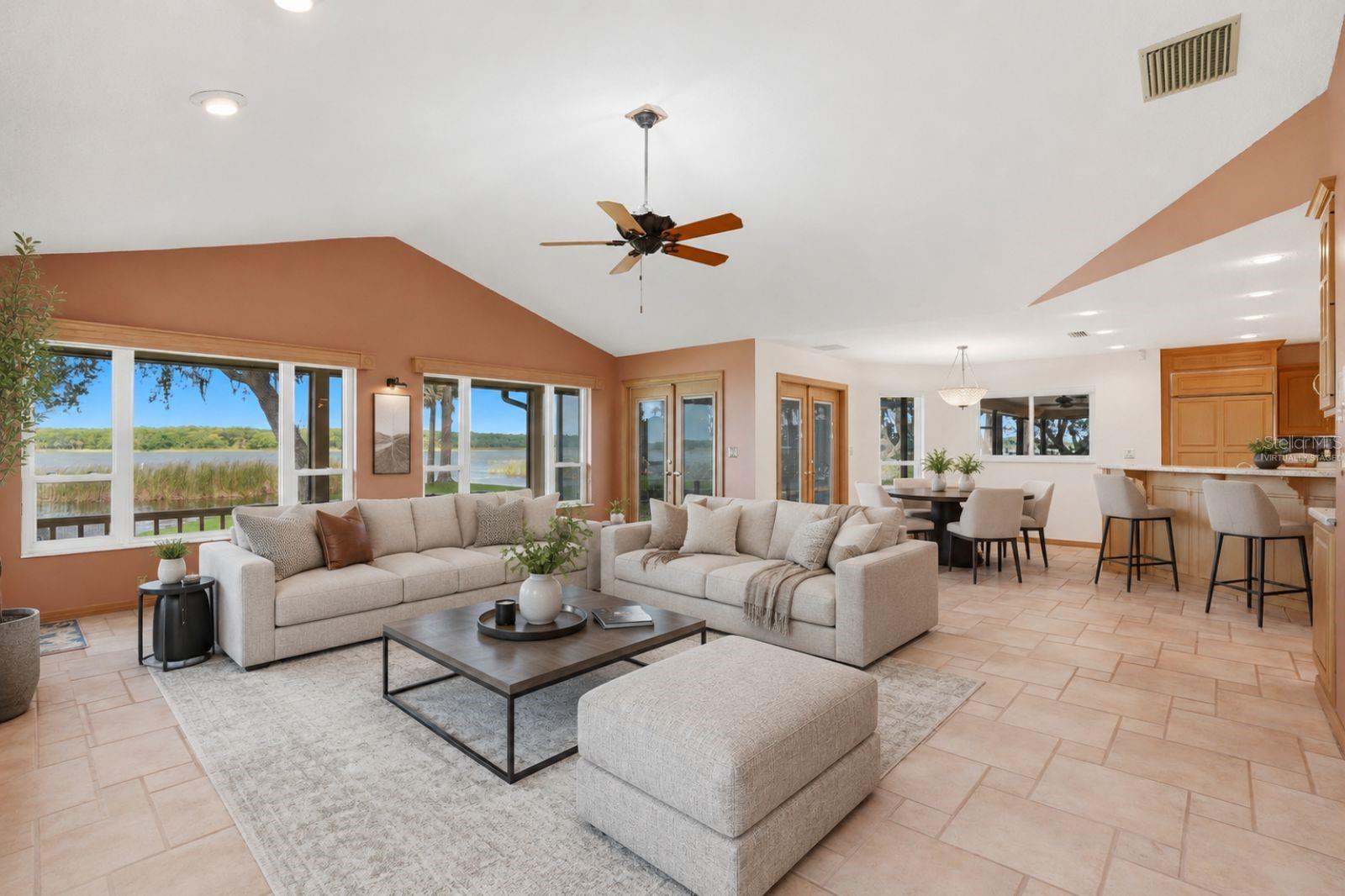 Open Family Room with woodburning fireplace andexpansive views of LakeTarpon and hurricane impactrated windows and Frenchdoors to the enclosed pool..Seamless flow to the kitchen,breakfast area, 3rd bath andpool area -virtually staged