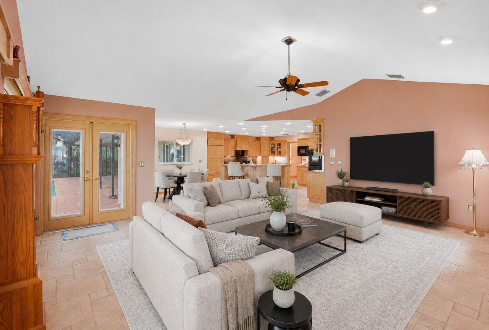 Open Family Room with woodburning fireplace andexpansive views of LakeTarpon and hurricane impactrated windows and Frenchdoors to the enclosed pool.Seamless flow to the kitchen,breakfast area, 3rd bath andpool area -virtually staged