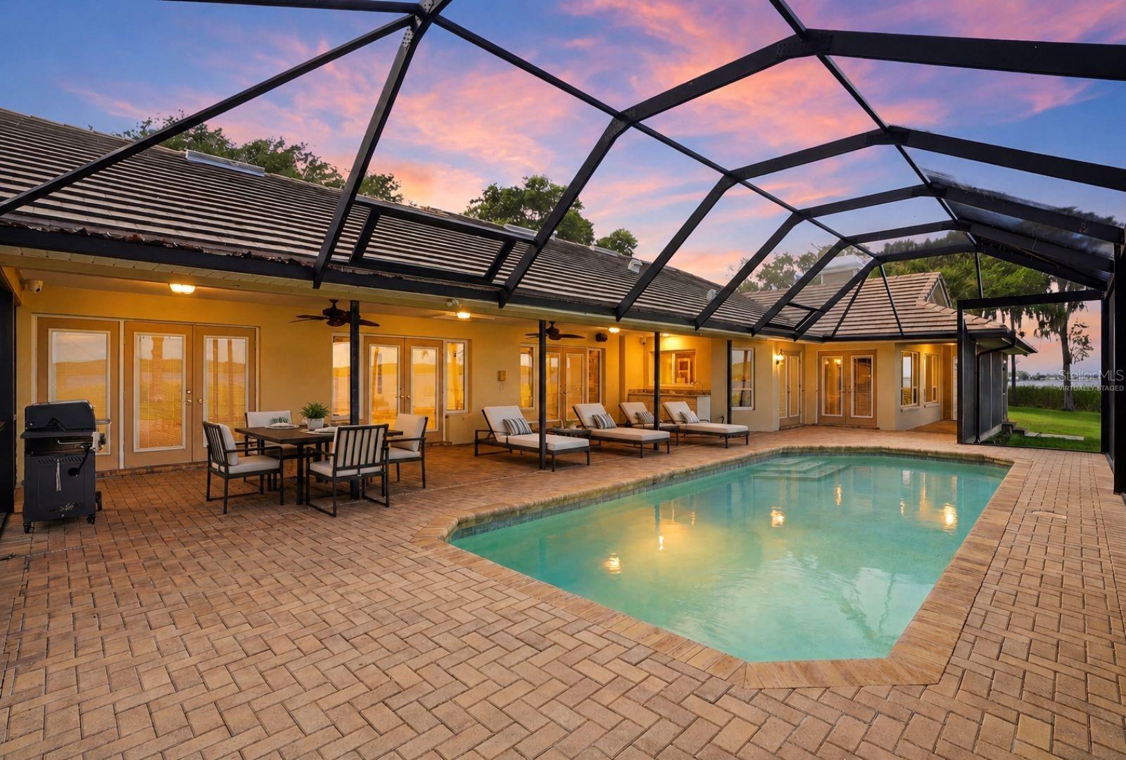 Covered Lanai and highvelocity pool enclosure withopen-view screen system,paver pool deck and PebbleTecpool offers year roundenjoyment-virtually staged