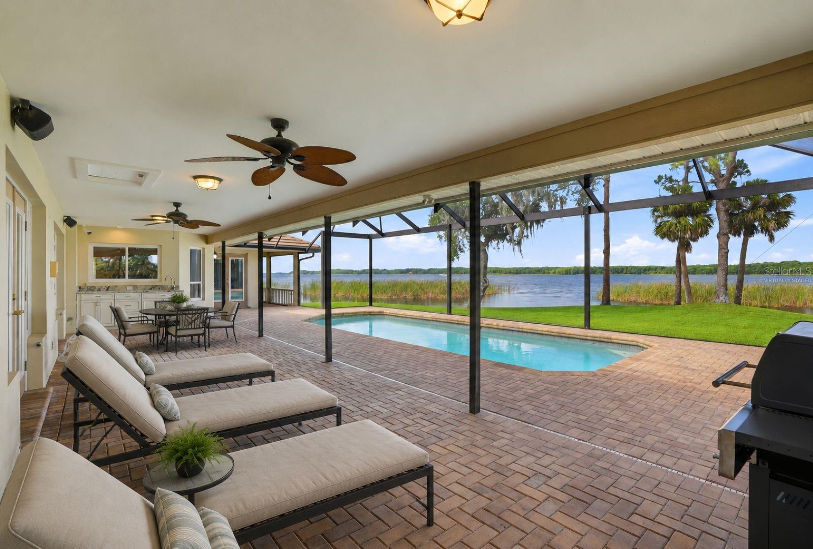 Covered Lanai and highvelocity pool enclosure withopen-view screen system,paver pool deck and PebbleTecpool offers year roundenjoyment and entertainingvirtually staged
