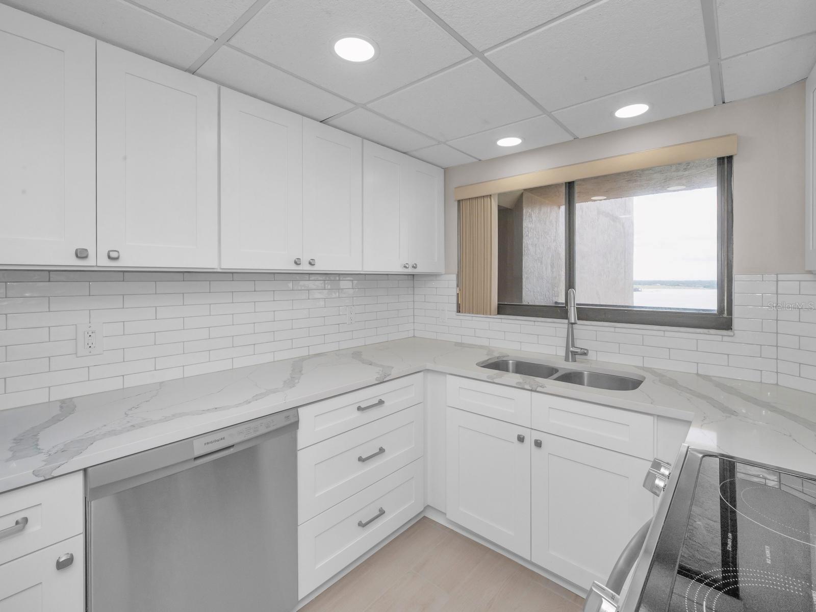Open Light & Bright Cucina with Quartz surfaces, Shaker Cabinetry, backsplash, recessed lighting equipped with Brand New stainless appliances. Cool Lighted Intracoastal REGATTA Views!