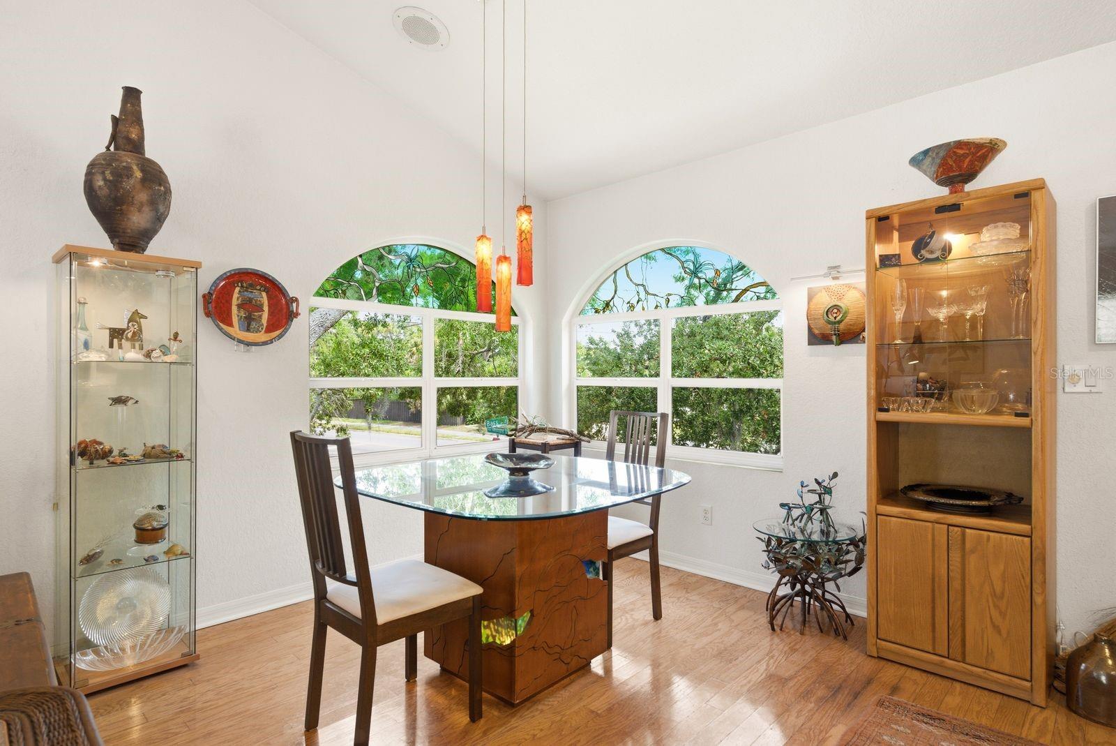 Dining area overlooks front and side yard with custom windows, light fixture handmade by artist from Azerbaijan.