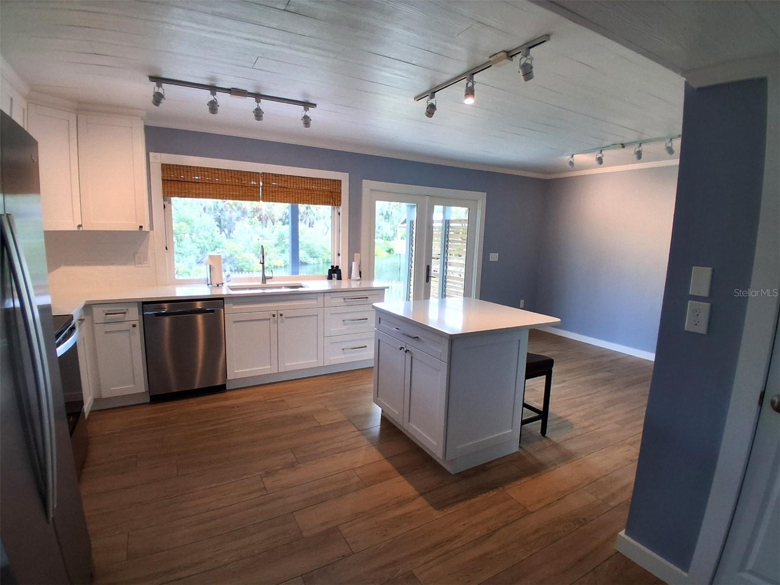 Huge country kitchen measures 20'x14'. New shaker style soft close cabinets, quartz counters, newer appliances, two pantries, spot lighting, and incredible water views from the giant window and French doors!
