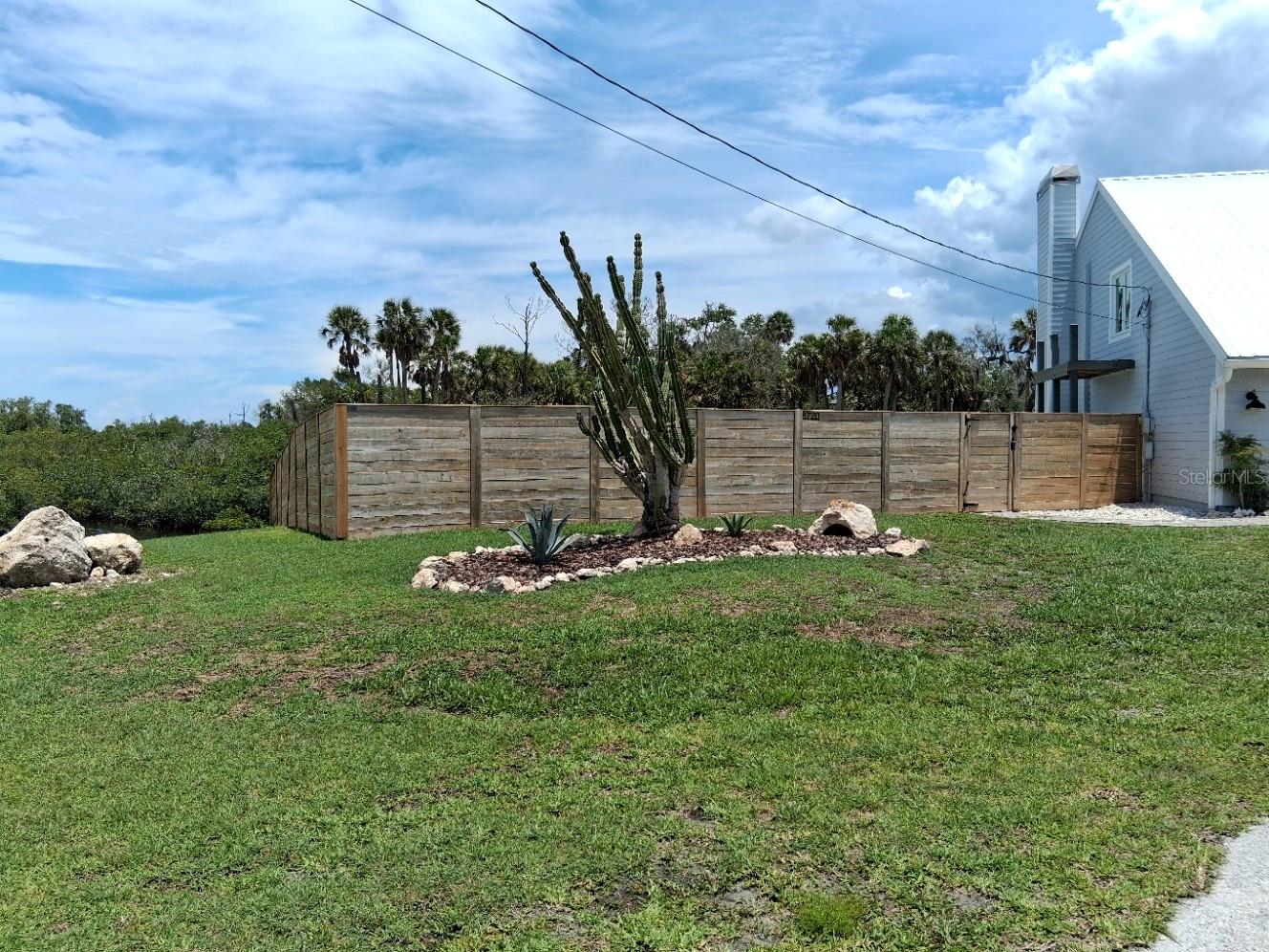 Large yard on the left with privacy fence around the pool