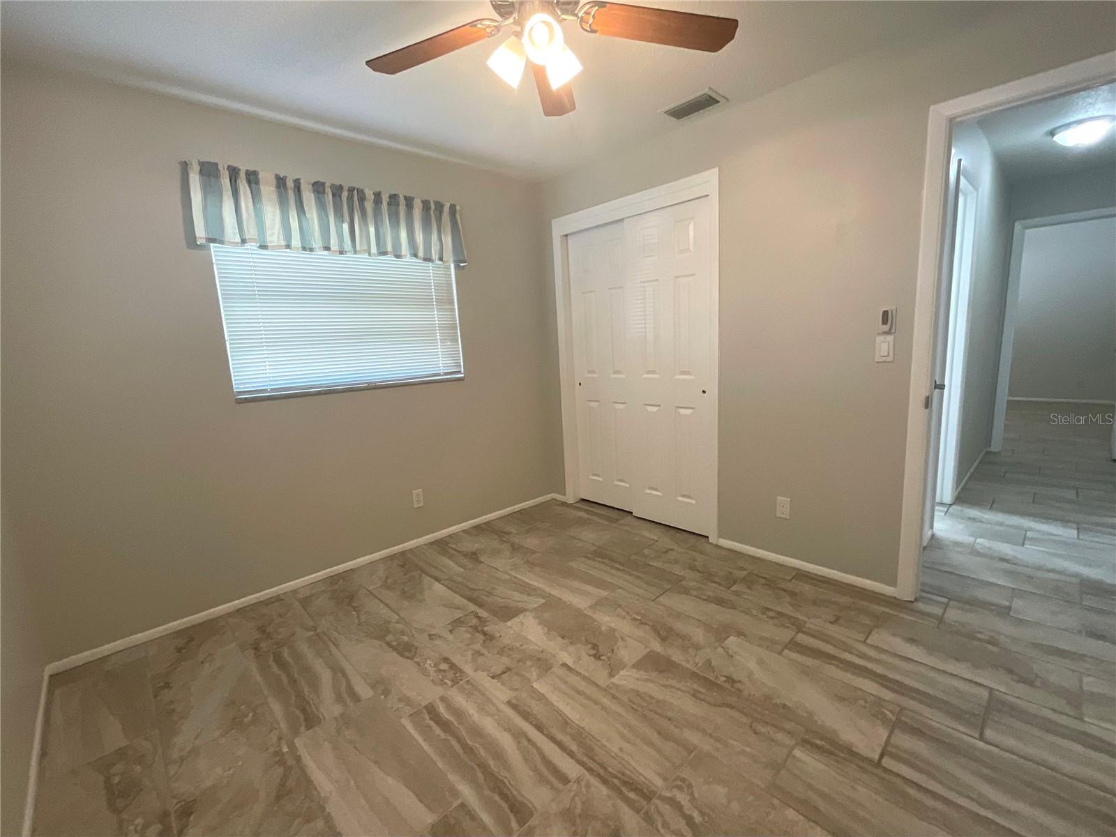 Guest bedroom view of window and closet