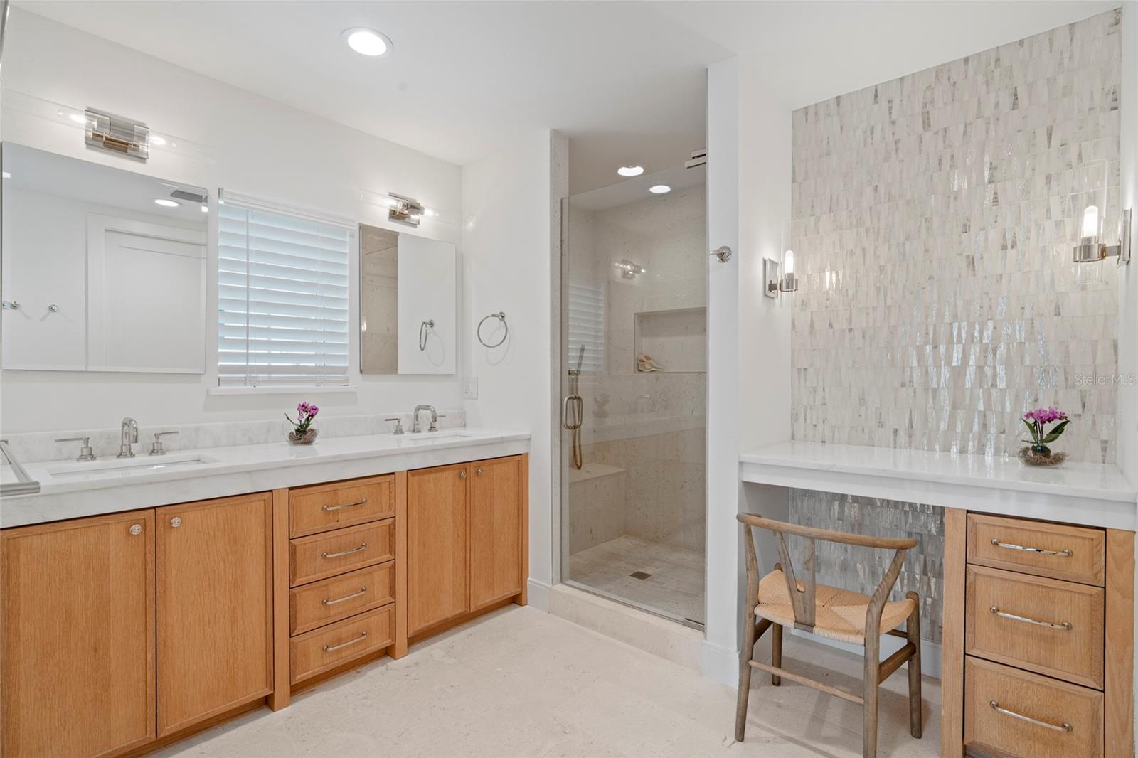 Master bath with custom cabinetry and shell mosaic tile wall