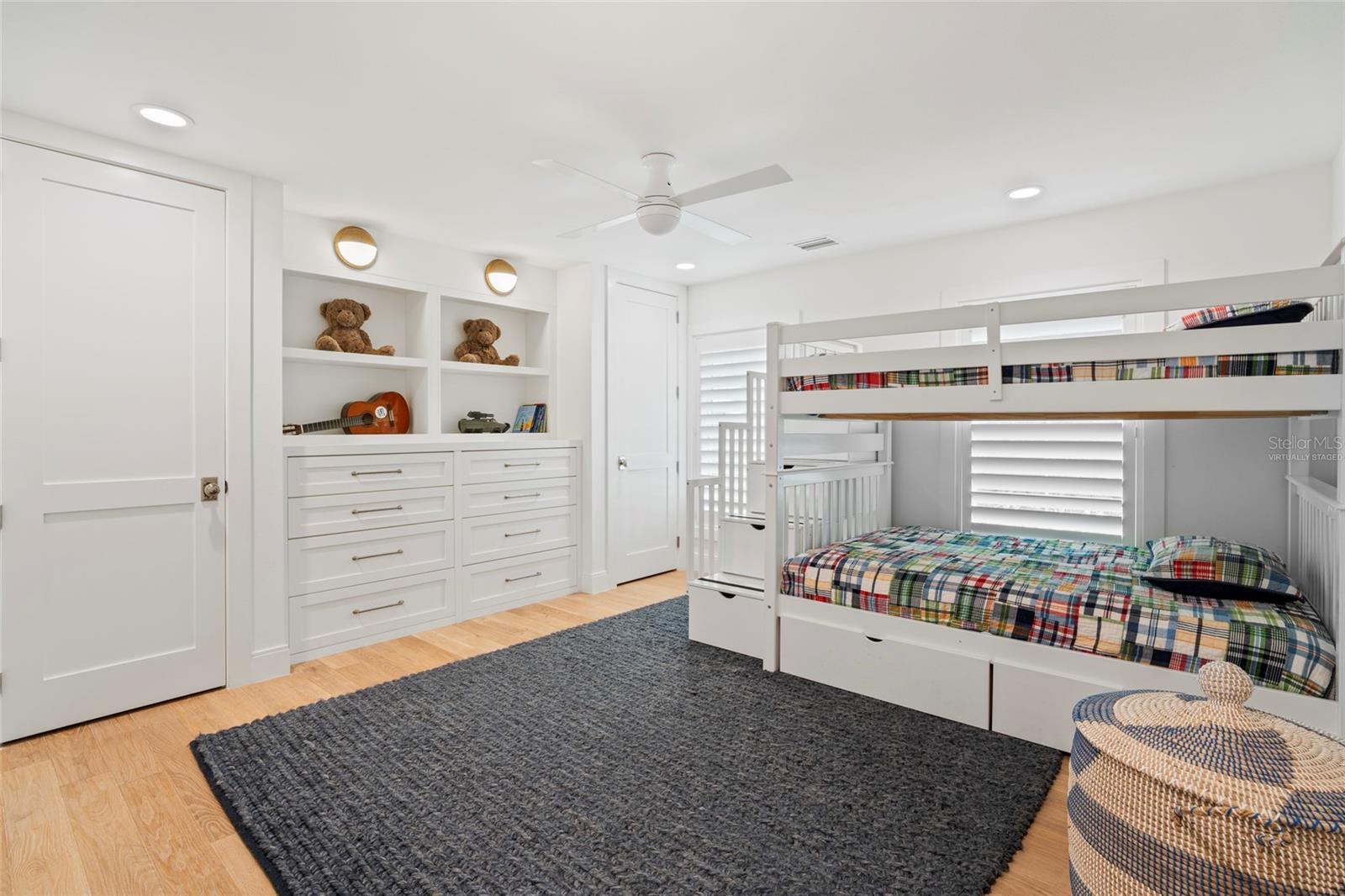 bedroom 3 w/ custom cabinetry, upscale sconce, fan & LED recess lighting, virtually staged