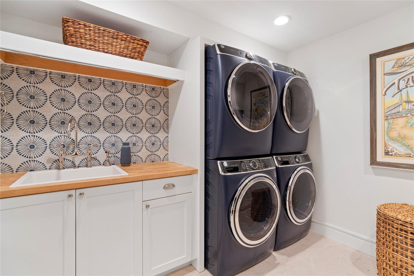 laundry sink w/ hand painted mosaic backsplash, double front load washer & dryer