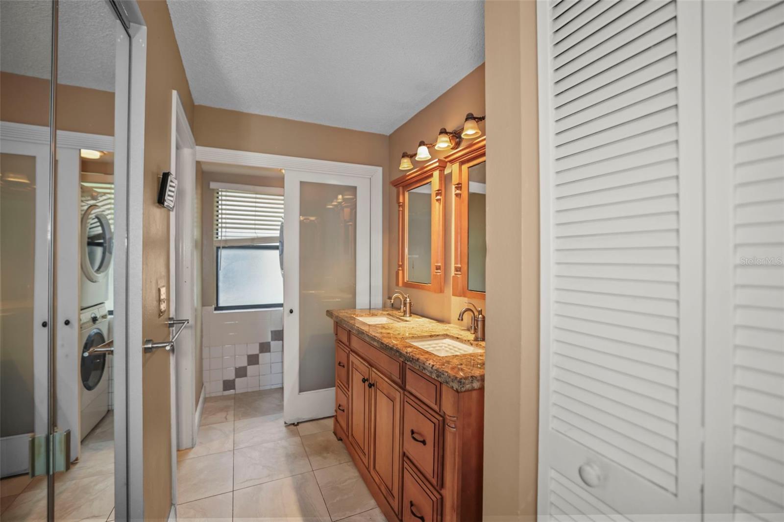 Primary Bathroom Showing washer dryer closet