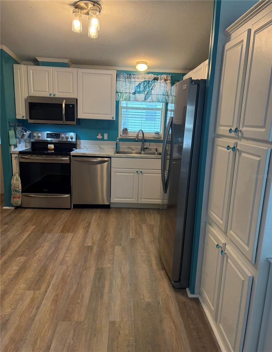 kitchen showing vinyl plank flooring.  Great pantry to the right!!