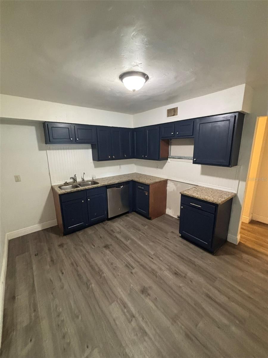 Fresh paint, vinyl flooring, and countertops in kitchen