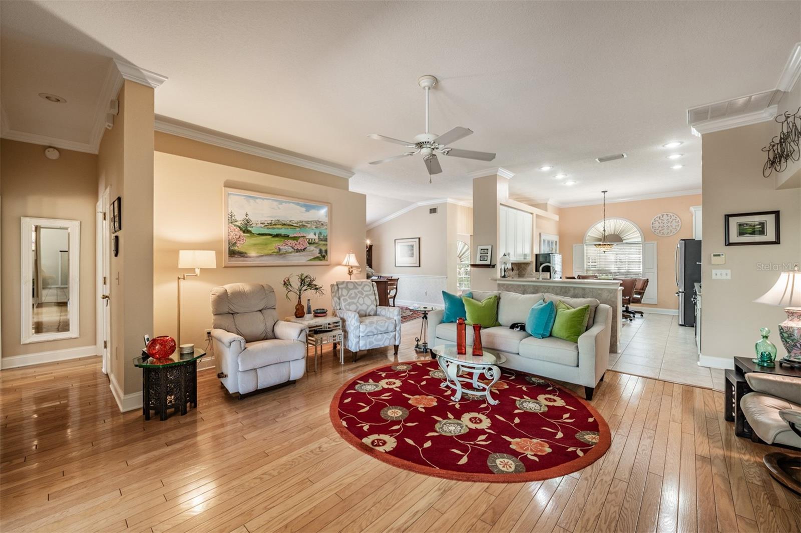 Open Floor plan, Hardwood Flooring, open to the Kitchen and Dining Room, Crown Molding and ceiling fan.