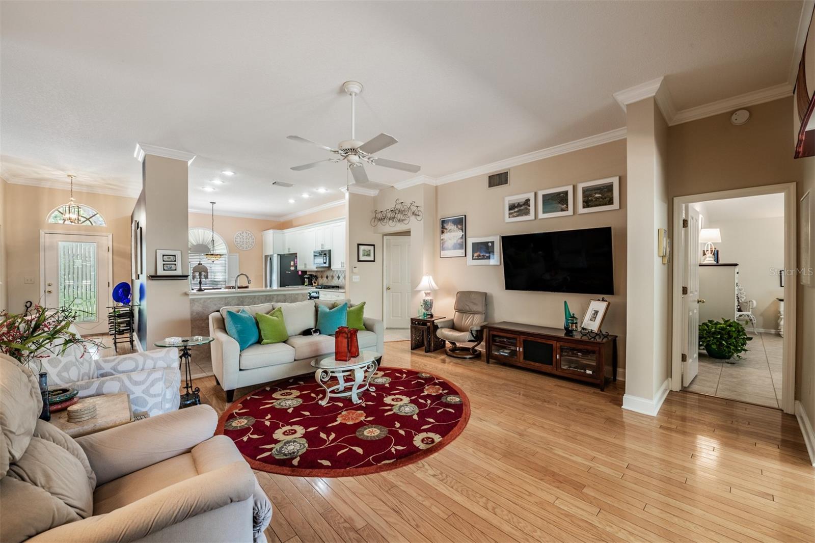 Open Floor plan, Hardwood Flooring, open to the Kitchen and Dining Room, Crown Molding and ceiling fan.